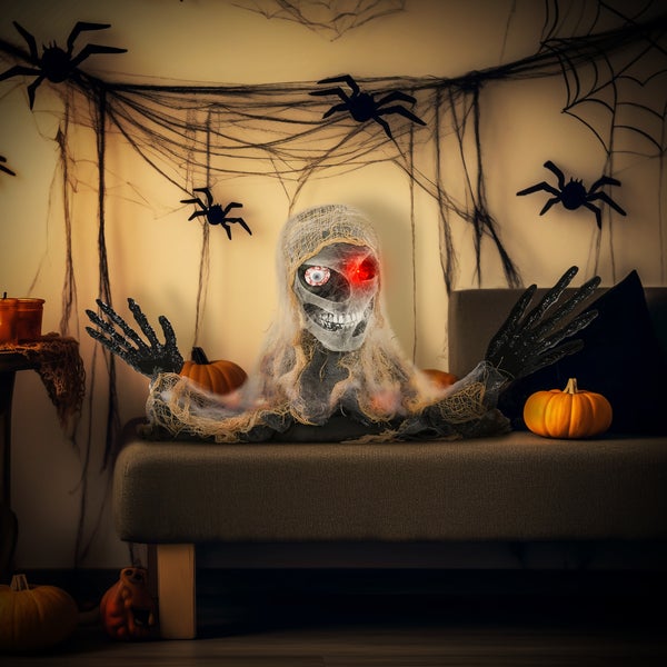 Halloweenská dekorace s mumií, pavučinou a dýněmi na pohovce