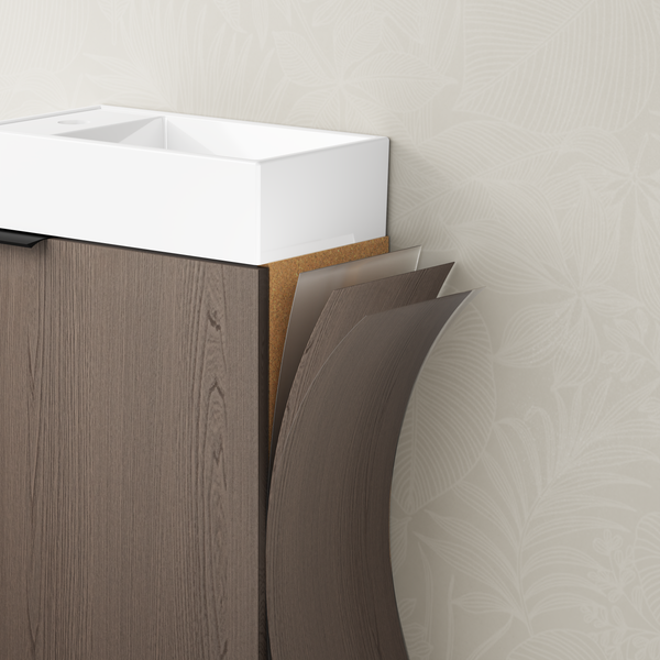 Skříňka pod umyvadlo se znázorněnou vrstvenou konstrukcí z dřevěného materiálu, kovové fólie a laminátu pod bílým umyvadlem.