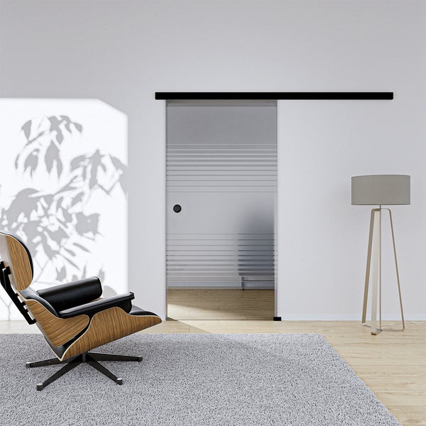 Obývací pokoj se skleněnými posuvnými dveřmi, křeslem a kobercem.