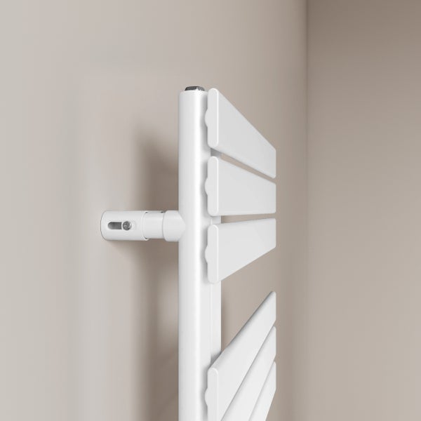 Detailní pohled na bílý topný žebřík na ručníky na zdi
