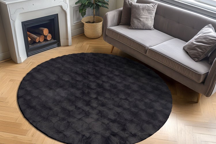 Kulatý koberec do obývacího pokoje s texturovaným povrchem v elegantně zařízeném interiéru s krbem a pohovkou na parketové podlaze.