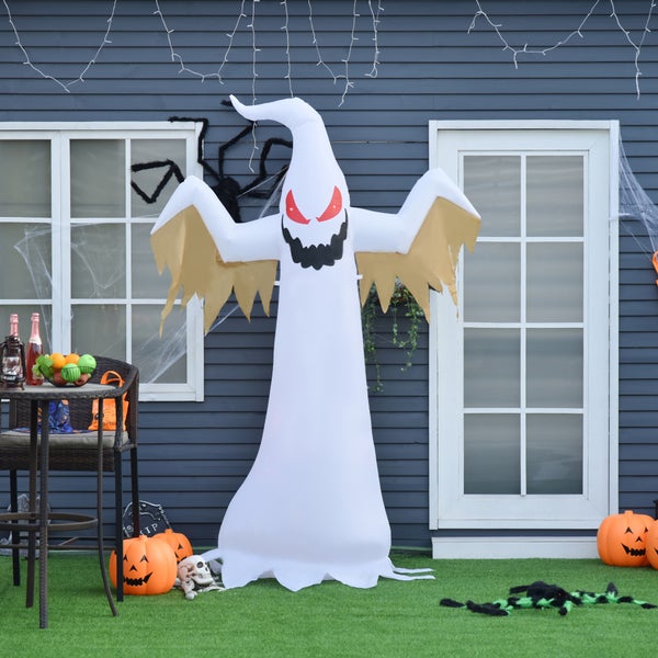 Scéna s halloweenskými dekoracemi, včetně nafukovacího ducha, dýní a pavučin před domem.