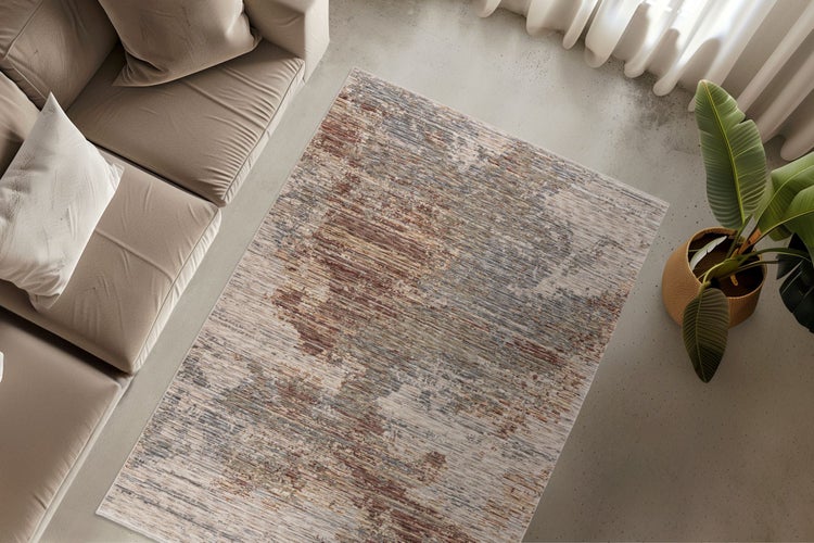 Obdélníkový koberec s abstraktním vzorem položený v moderním obývacím pokoji před pohovkou na betonové podlaze.