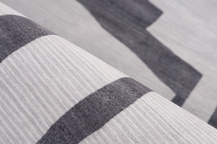 Detailní pohled na koberec s pruhovaným vzorem v moderním tkaném vzhledu