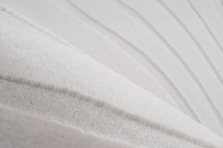 Detailní záběr na nadýchaný textilní materiál s jemnou strukturou povrchu.