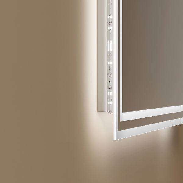 Detailní pohled na LED zrcadlo s nepřímým osvětlením na stěně a viditelným LED páskem v rámu.