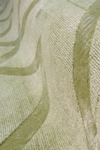Detail koberce s reliéfním vzorem a vlnitou strukturou s vysokým a nízkým vlasem.