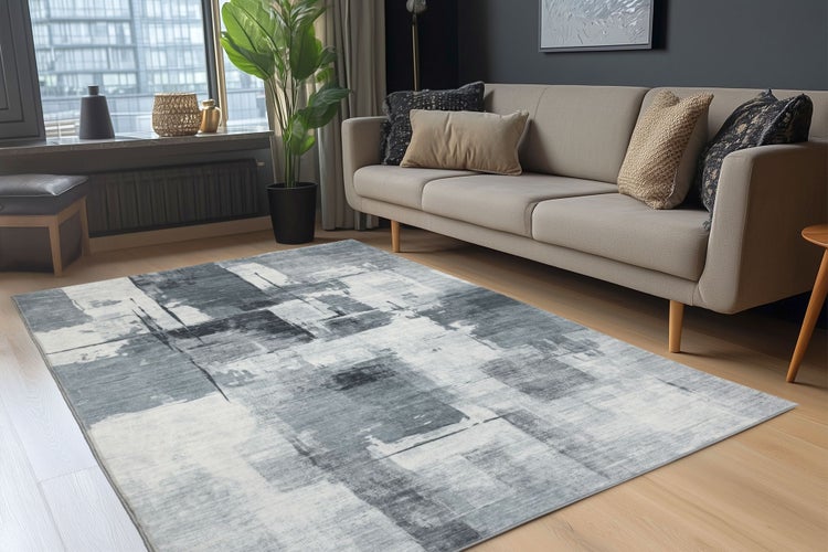 Obývací pokoj s moderním kobercem s abstraktním vzorem před pohovkou na světlé dřevěné podlaze.