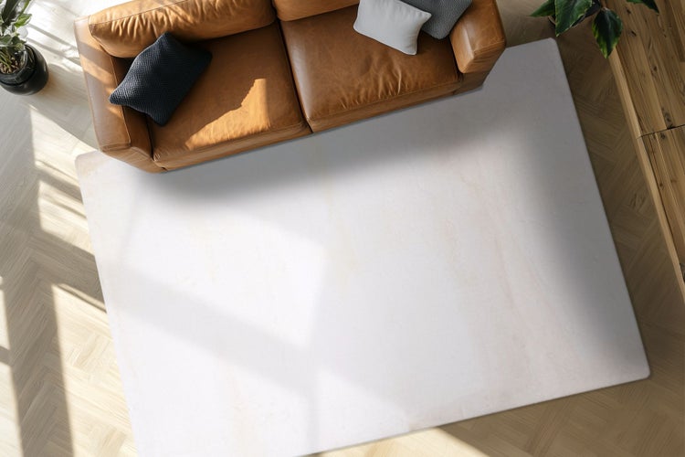 Světlý obdélníkový koberec před pohovkou na světlé parketové podlaze v moderně zařízeném obývacím pokoji.