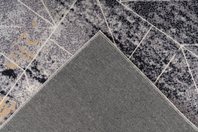 Koberec s geometrickým vzorem a detailní tkanou zadní stranou.