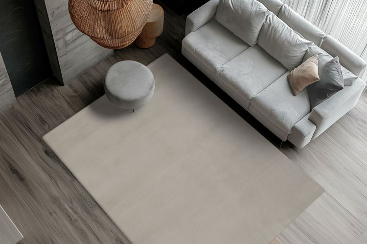 Moderní obývací pokoj z nadhledu s velkým obdélníkovým kobercem před pohovkou na dřevěné podlaze.