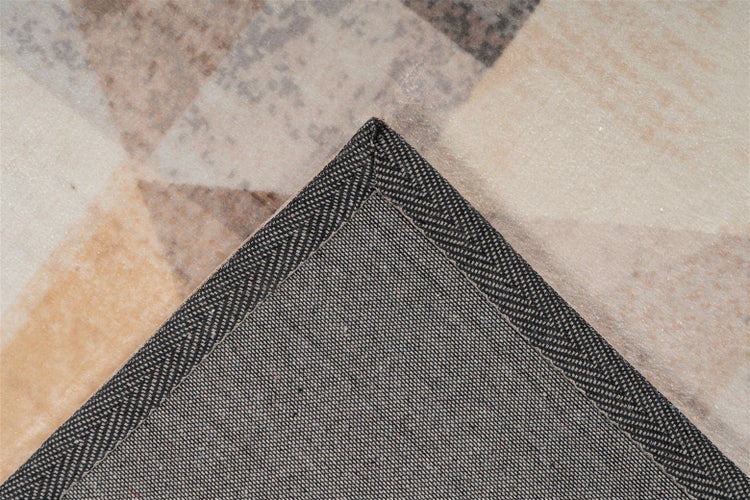 Detailní záběr na strukturovanou spodní stranu a obšitý okraj koberce s geometrickým vzorem.