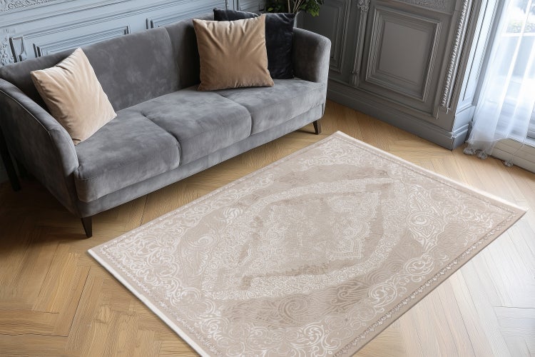 Moderní koberec do obývacího pokoje s orientálním vzorem na rybinové parketové podlaze před pohovkou v elegantně zařízeném obývacím pokoji.