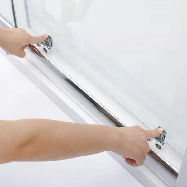 Detailní záběr sprchy s posuvnými dveřmi a prsty na vedení válečků