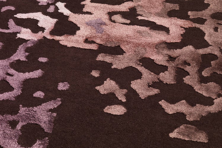 Moderní koberec s abstraktním vzorem a strukturovaným povrchem v detailním záběru.