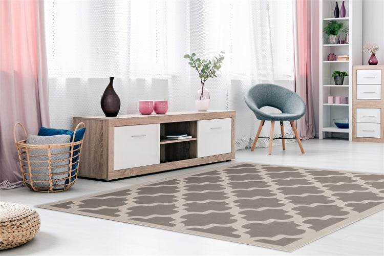 Obývací pokoj v moderním stylu s kobercem s geometrickým vzorem, dřevěným TV stolkem, křeslem a regálem.