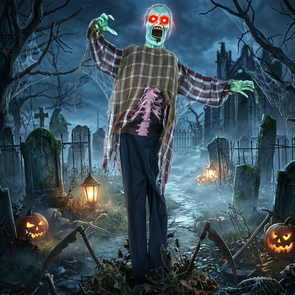 Halloweenská dekorativní figurka zombie se svítícíma očima na hřbitově s dýněmi a náhrobky.