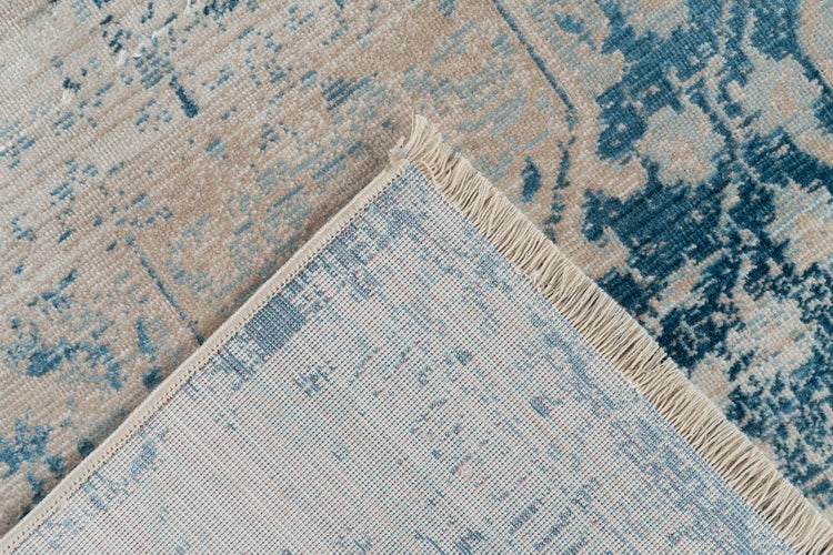 Detailní záběr koberce s vintage vzorem, třásněmi a detailem rubové strany.