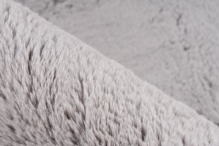 Detailní pohled na měkký umělý kožešinový materiál pro bytový textil, jako jsou deky nebo polštáře