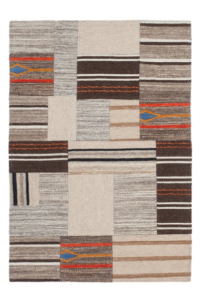 Plochě tkaný koberec v patchwork designu s pruhovanými vzory a geometrickými detaily v zemních tónech.