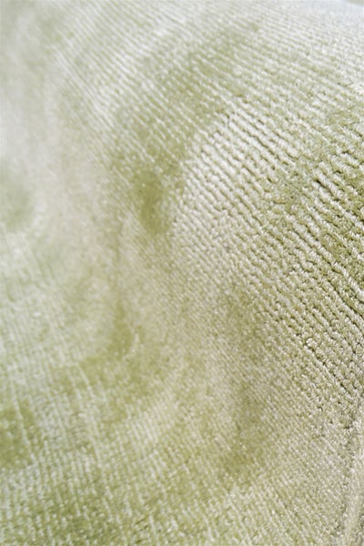 Detailní záběr měkké, žebrované textury látky ve světle zelené barvě pro bytový textil nebo čalounění.